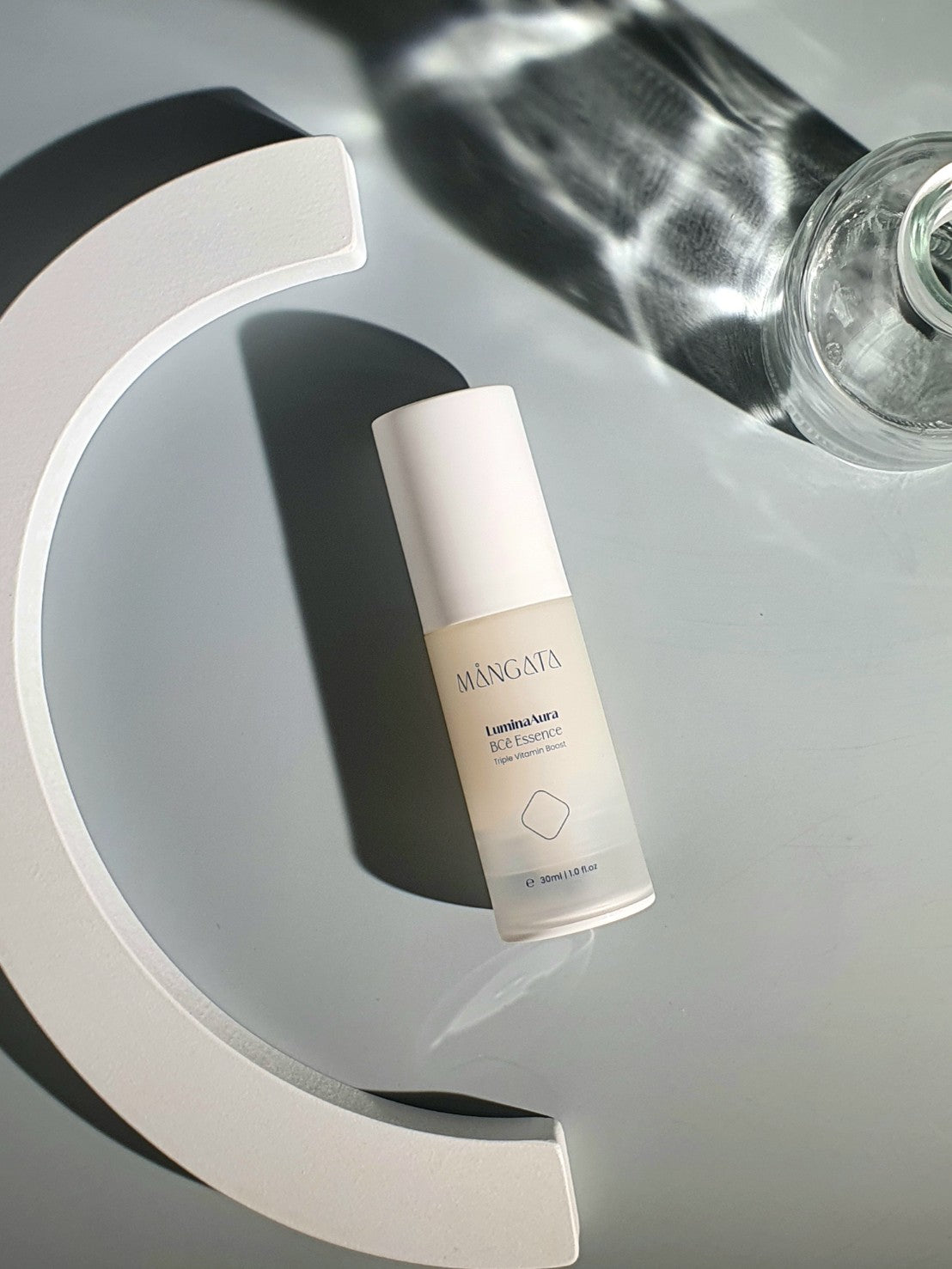 Cream bottle lying on a mint-colored background, showcasing sleek and minimalist packaging.