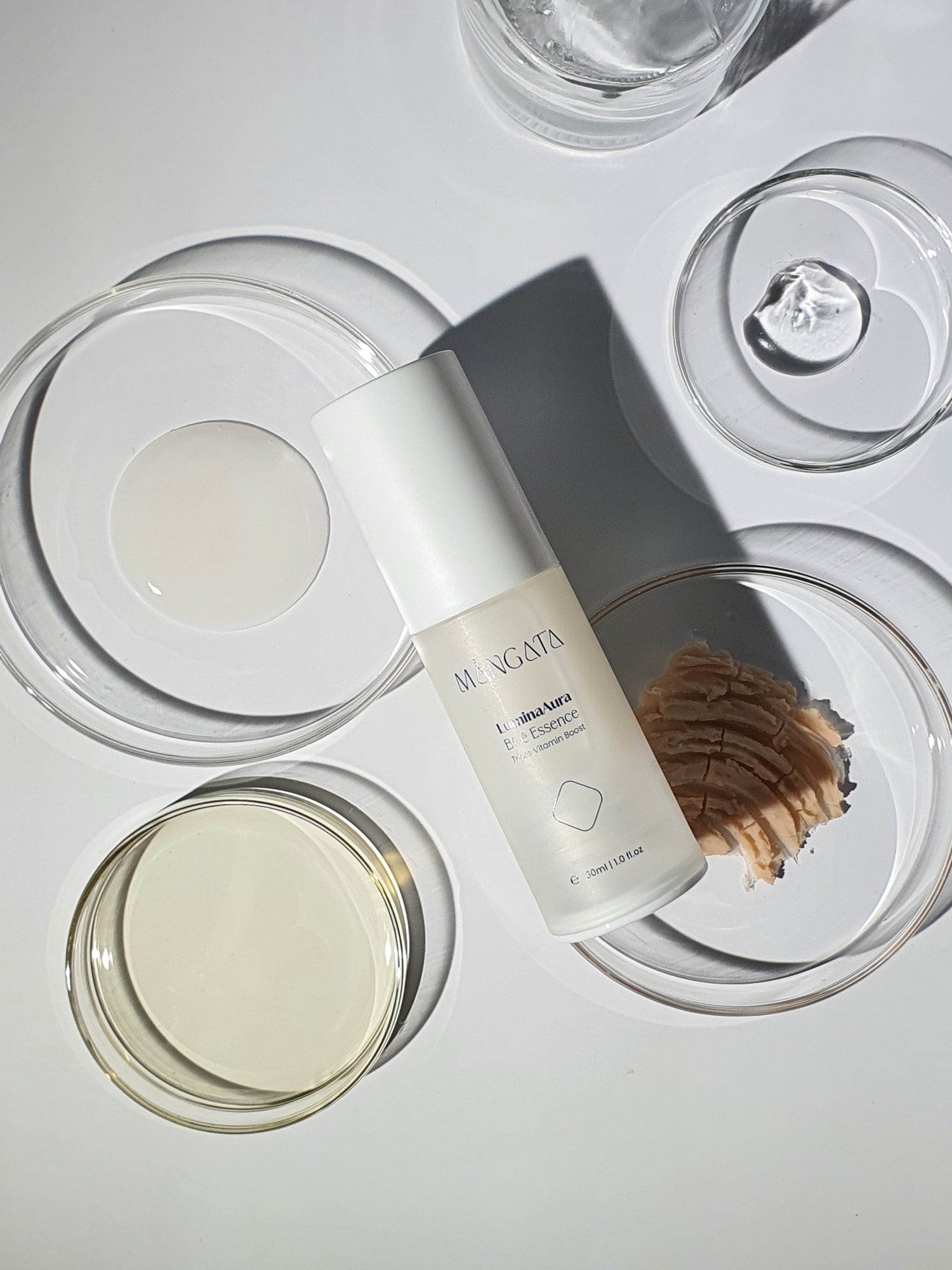 Elegant bottle lying on petri dishes filled with various raw materials and natural ingredients.