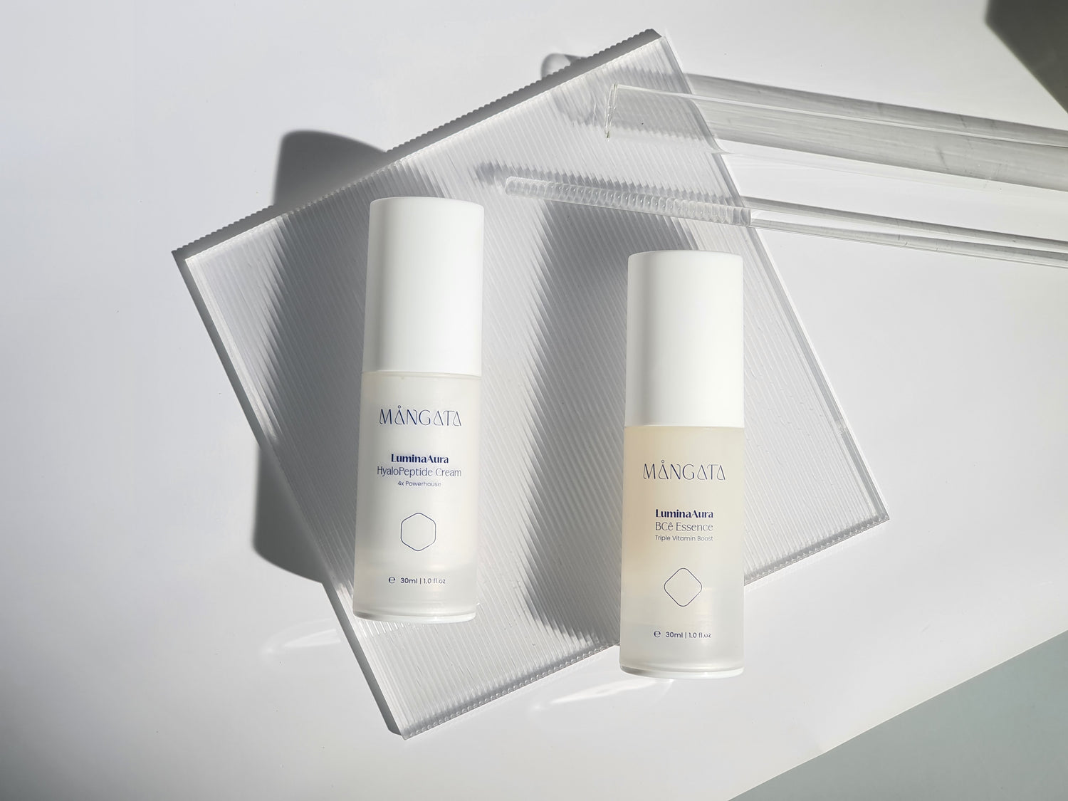 Two skincare products arranged side by side on a transparent square pleated plate, showcasing their elegant packaging.