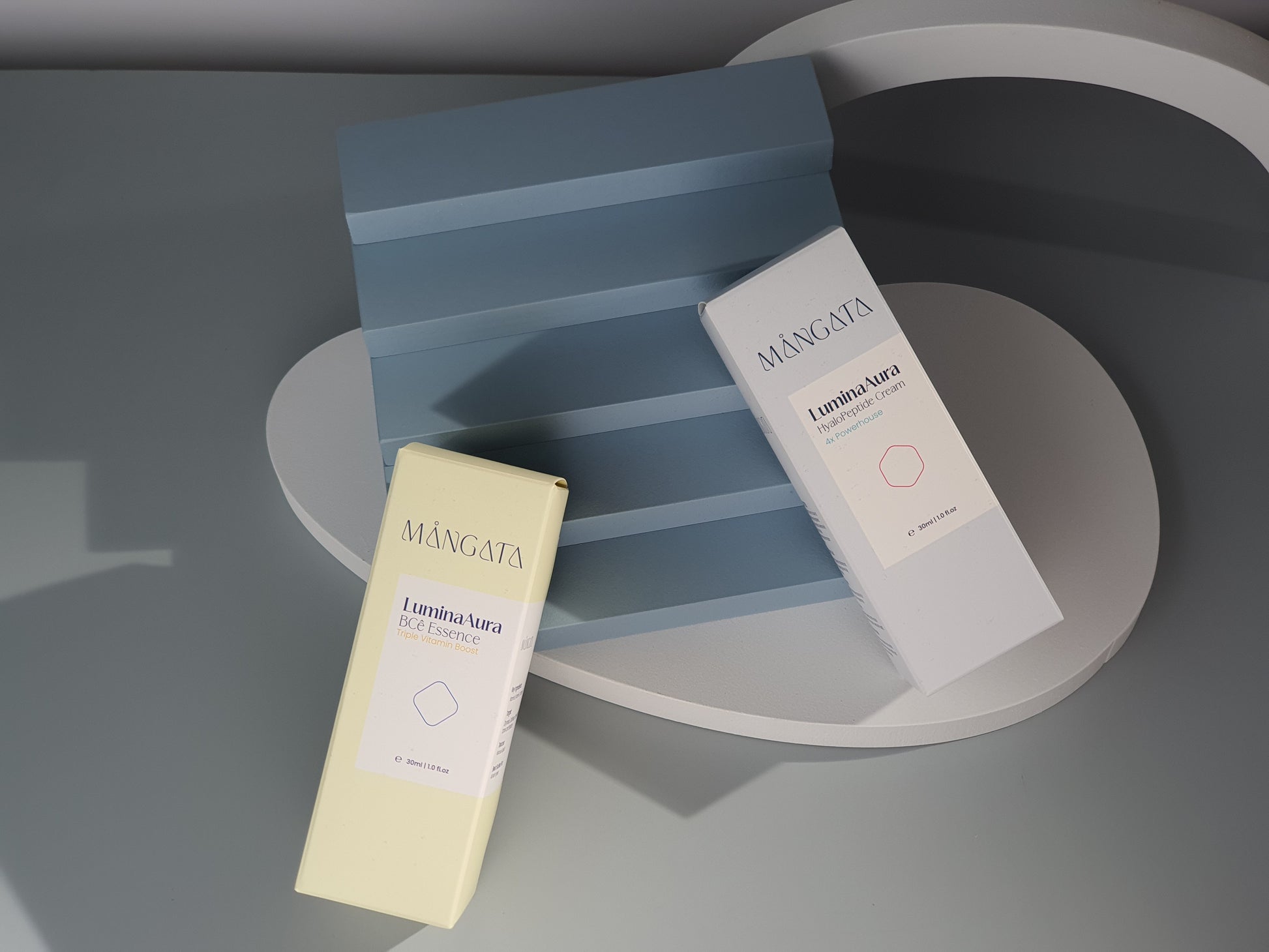 Two elegant closed skincare box with a minimalist design and brand logo on the front, lying on blue staircases.